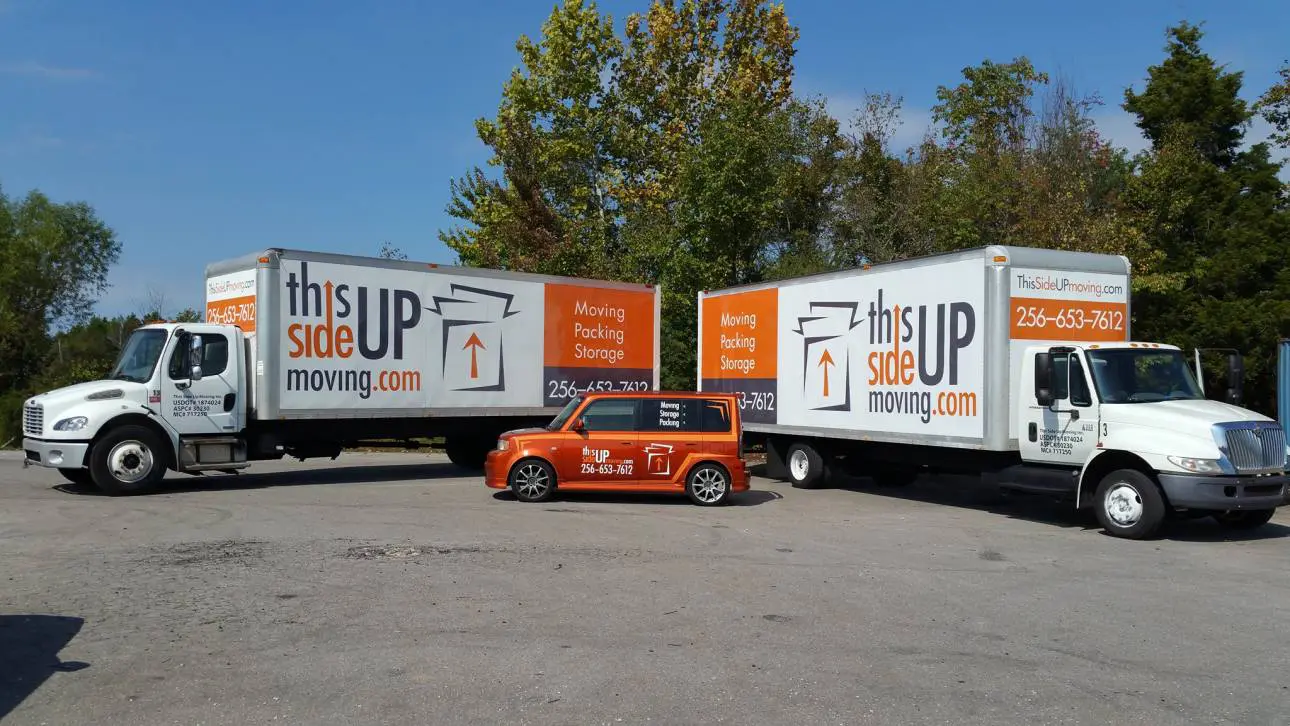 a white moving truck parked in front of a commercial building in Madison Alabama